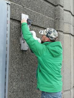 Image of Ben attaches the IR illuminator above the PTZ camera, which needed a new network cable. 