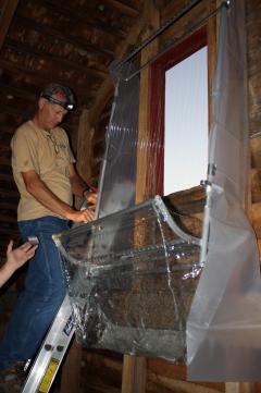 Image of Mick Valent and the team set up a harp trap to catch bats as they exit the barn loft at dusk.